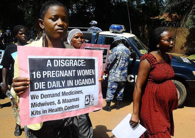 Activists carry placards outside the Constitutional court during a peaceful march in the capital Kampla on May 22, 2012 to protest the delay by a Ugandan court to deliver a ruling in a landmark lawsuit regarding the cases of two women who unattended bled to death while giving birth in Ugandan hospitals.
