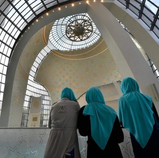 Visitors stand in the new central DITIB mosque on the "Day of Open Mosques" in Cologne, Germany, Tuesday, Oct. 3, 2017. (AP Photo/Martin Meissner)