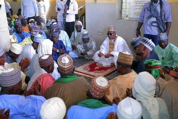 Borno State Governor Babagana Umara Zulum (centre) prays during the funeral in Zabarmari
