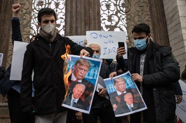 Protesters in Iran burning pictures of Donald Trump and Joe Biden after the assassination last week of Iran’s leading nuclear scientist.