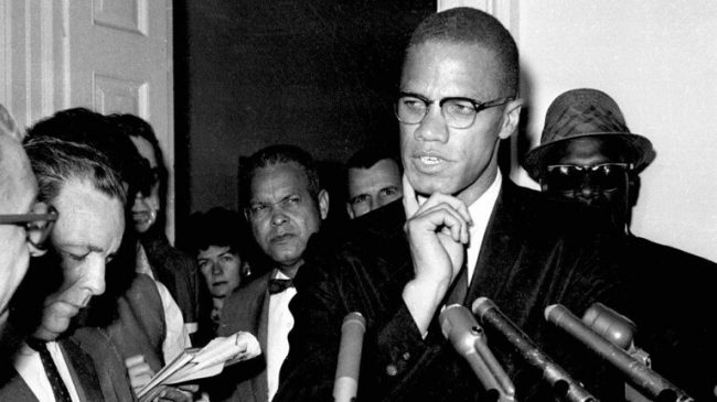 In this 1963 photo, civil rights leader Malcolm X speaks to reporters in Washington. (AP)