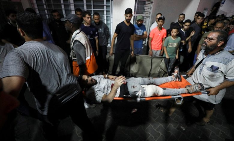 Injured people are assisted after Israeli strike hit At Al-Ahli Hospital, according to Gaza Health Ministry