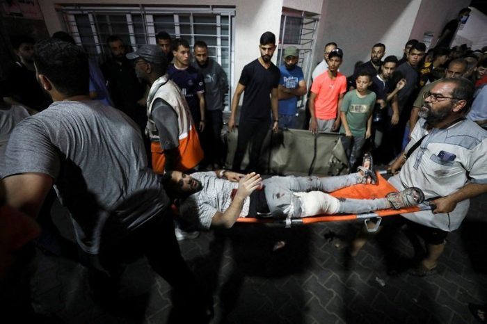 Injured people are assisted after Israeli strike hit At Al-Ahli Hospital, according to Gaza Health Ministry